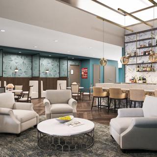 A modern and inviting lounge area featuring comfortable seating and a stylish bar.