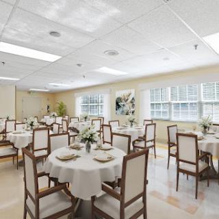 An elegantly designed dining room featuring round tables set for a formal meal.
