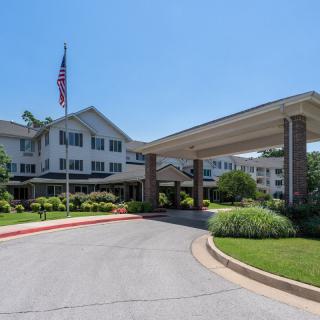 Entrance of a large building with a driveway and American flag.