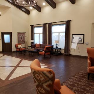 A spacious and inviting lobby featuring comfortable seating, wooden beams, and natural light.