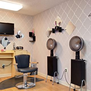 A cozy and modern hair salon setup with a comfortable barber chair and stylish wall decor.
