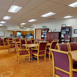 A spacious library reading room with tables, chairs, and bookshelves.