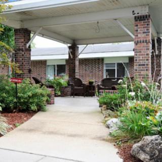 A charming outdoor porch with lush garden landscaping and comfortable seating.
