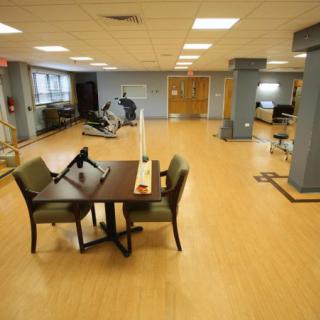 A rehabilitation center therapy room equipped with exercise machines and furniture for therapy sessions.