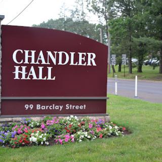 Entrance sign for Chandler Hall located on Barclay Street, surrounded by flowers.