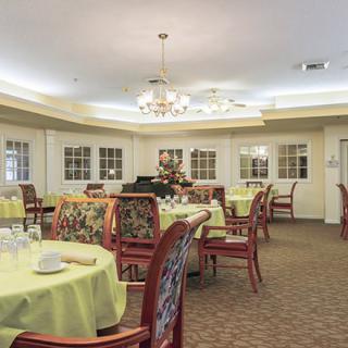 An elegantly decorated dining room with several tables and chairs neatly arranged.