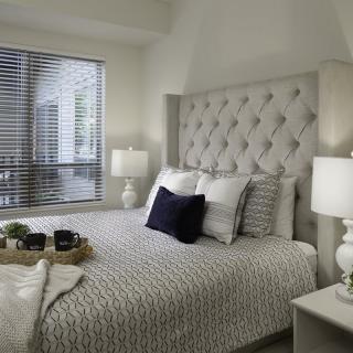 A cozy bedroom with elegant decor and a plush bed adorned with pillows.