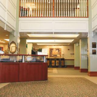 A hotel lobby featuring a reception desk and open seating area.
