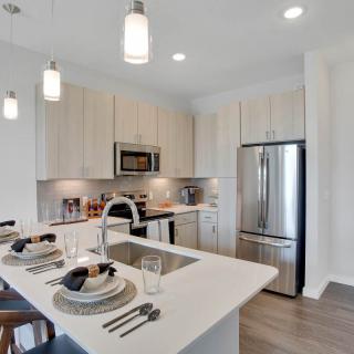 A modern kitchen with a sleek design, featuring stainless steel appliances and a stylish dining area.