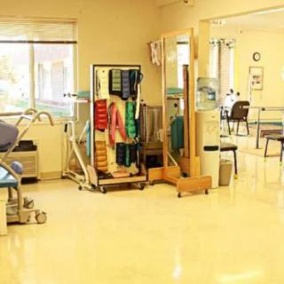 A physical therapy room with various rehabilitation equipment and exercise areas.