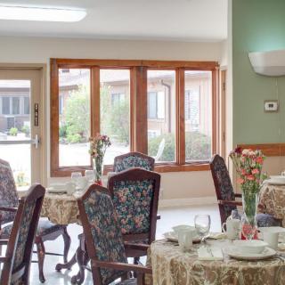 A cozy dining room with elegant furniture and floral decorations.