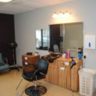 An interior view of a hair salon with styling stations and chairs.