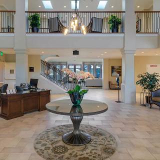 Elegant lobby with a chandelier, decorative table, and staircase.