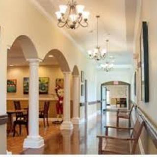 A well-lit hallway with elegant columns and comfortable seating.