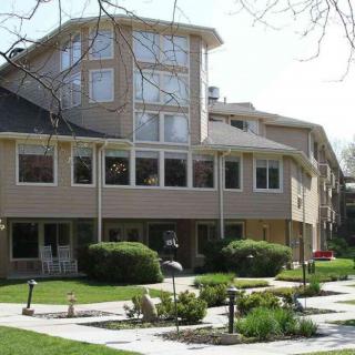 A view of a residential building with large windows and a well-maintained garden.