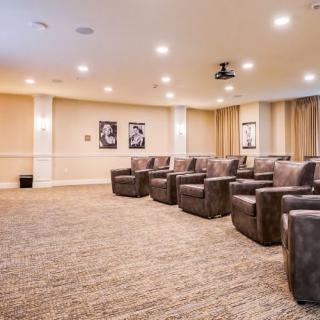 A spacious home theater with comfortable seating and a projector.
