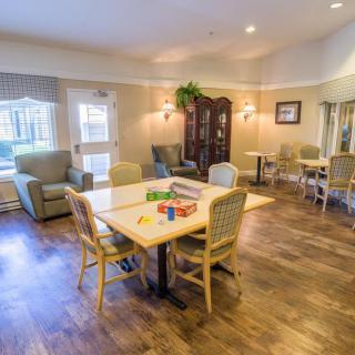 A cozy, well-furnished living room with tables and chairs arranged for social gatherings.
