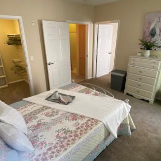 A cozy bedroom with neatly arranged furniture and soft lighting.