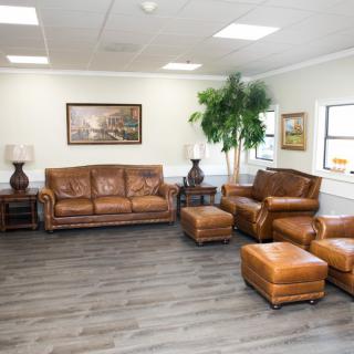 A spacious living room with leather furniture and hardwood flooring.
