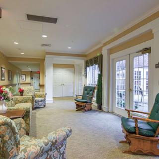A cozy living room with patterned furniture and large windows.