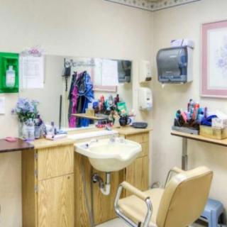 A well-equipped hair salon with a sink, mirror, and styling chair.