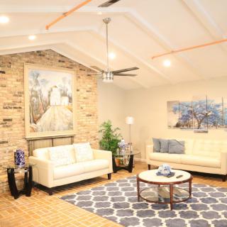 A modern living room with a stone accent wall, stylish sofas, and elegant decor.