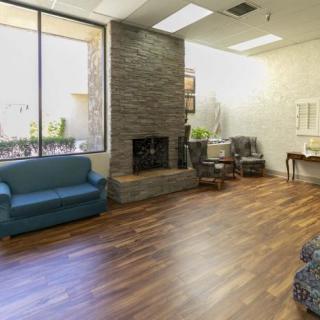 A cozy living room with a fireplace, sofas, and wood flooring.