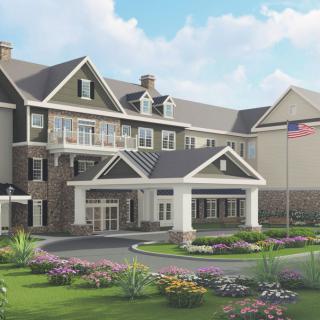 A beautifully landscaped residential building with an American flag.