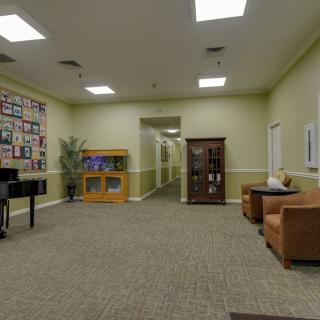 A comfortable lobby area featuring a piano and seating, leading to a hallway.