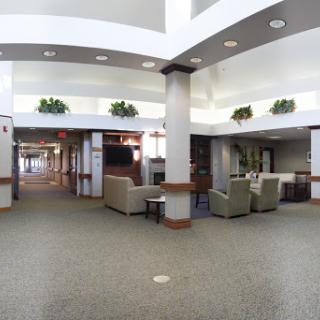 A spacious and modern lobby featuring comfortable seating areas and decorative plants.