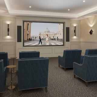 A luxurious home theater room featuring comfortable seating and a large screen.