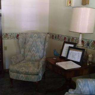 A cozy living room corner with an armchair and a lamp on a side table.