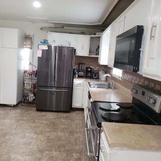 A modern kitchen with stainless steel appliances and white cabinets.
