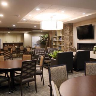 A modern lounge area with comfortable seating, a television, and warm lighting.