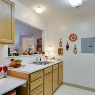 A cozy kitchen interior featuring wooden cabinets, a sink, and decorative items on the walls.