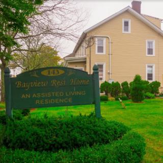 A charming residential house with a welcoming sign in the foreground.