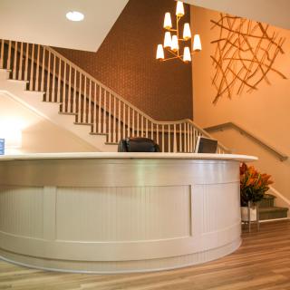 A modern reception area with a staircase and elegant lighting.
