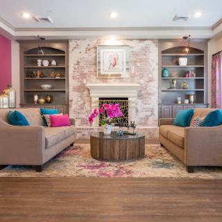 A stylish and inviting living room featuring modern decor, a cozy fireplace, and vibrant color accents.