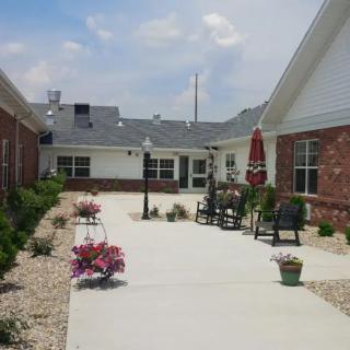 A serene courtyard with outdoor seating and landscaping between brick buildings.