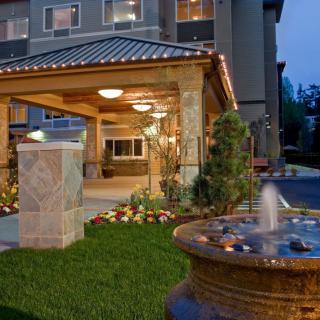 A hotel entrance featuring a decorative fountain and landscaped area at night.