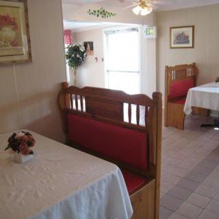 A cozy restaurant dining area with booth seating and white tablecloths.