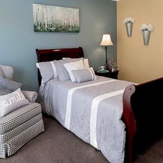 Cozy bedroom with a neatly made bed and tasteful decor.