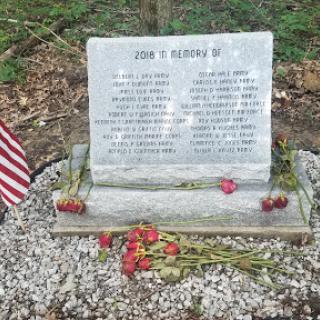 A memorial honoring the life of a loved one, adorned with flowers and an American flag.
