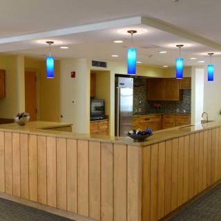 Modern reception area with wooden counter and blue pendant lights.
