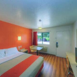 A cozy hotel room featuring an orange accent wall and modern furnishings.