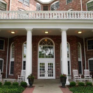 A grand residential entrance featuring elegant columns and a brick facade.