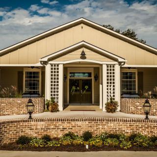 A well-maintained house with a brick front yard and decorative columns.
