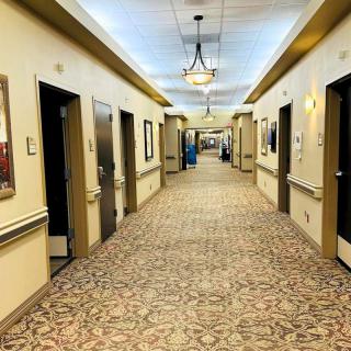 A well-lit, carpeted hallway with multiple doors on each side.