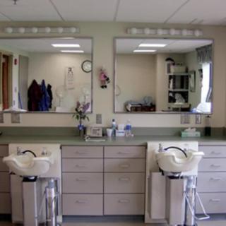 A hair salon with two styling stations featuring mirrors, sinks, and chairs.