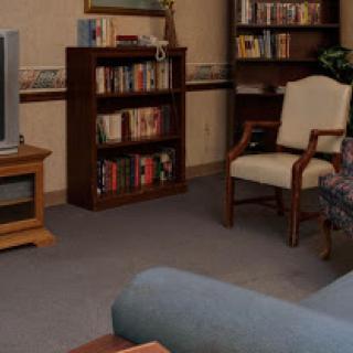 A cozy living room featuring a bookshelf, television, and comfortable seating.